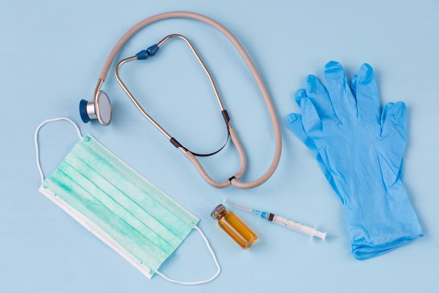 Protective medical mask, syringe, medicine in a bottle, gloves and a stethoscope