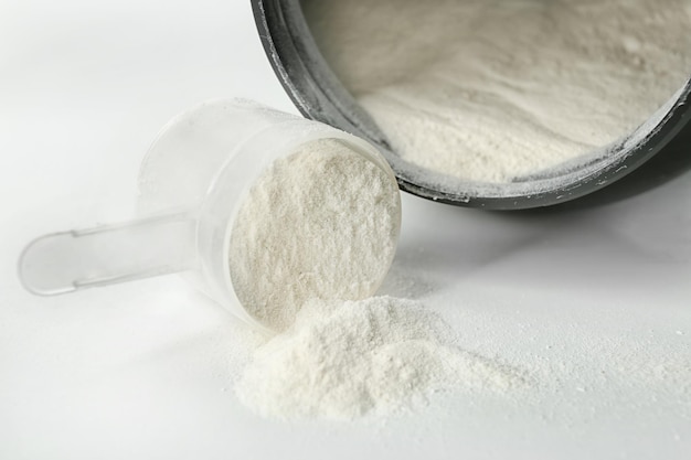 Protein powder and scoop on white background