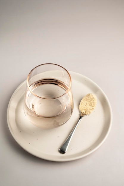 Protein powder and a spoon with glass of water Food supplements