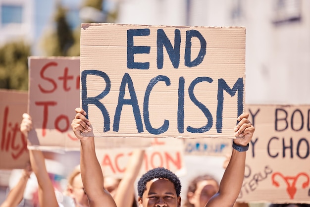 Protest racism poster and walking people for human rights black lives matter and inequality movement on city street in USA Angry crowd with sign for freedom justice and change in government