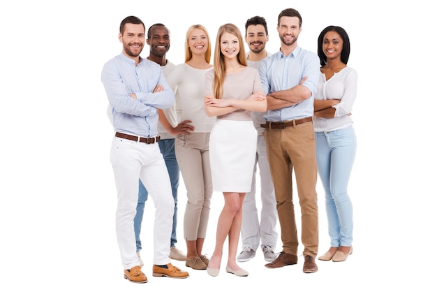 Proud to be a team. Full length of multi-ethnic group of people in smart casual wear looking at camera and smiling while standing against white background