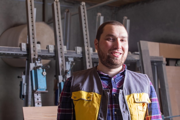 Proud carpenter at woodworking factory working place