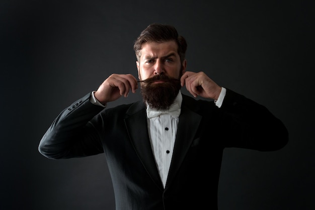 Proud of his moustache. Brutal hipster twirl moustache. Serious guy wear long beard and moustache. Bearded man with stylish moustache hair. Barbershop. Barbers.