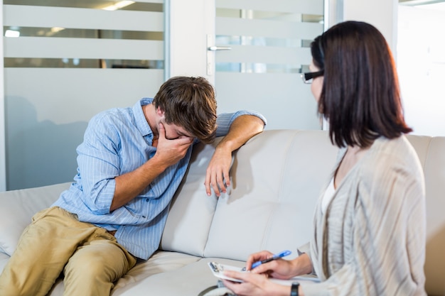 Psychologist talking with depressed man