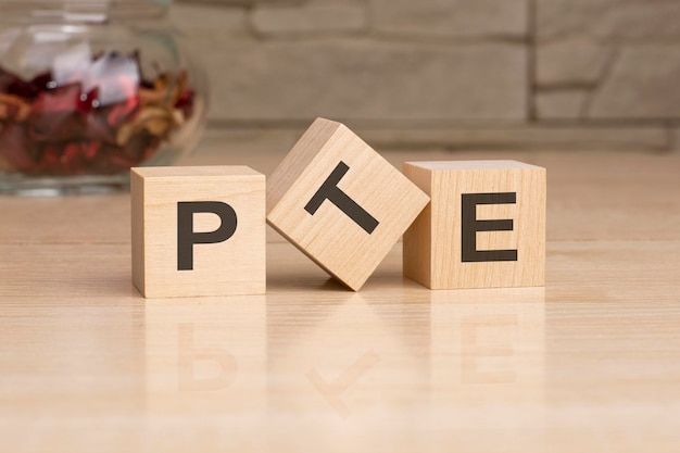 PTE acronym from wooden blocks with letters pearson tests of english PTE concept foreign language exams top view on grey background