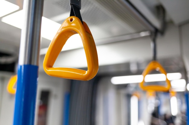 Public transport in the city Yellow handrails for hands closeup modern subway car