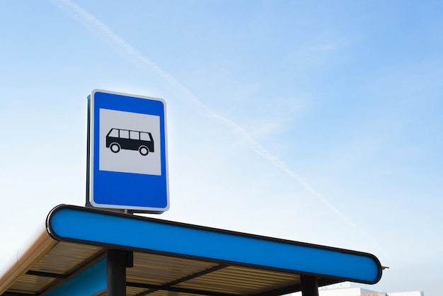 Public transport stop sign on light blue sky background