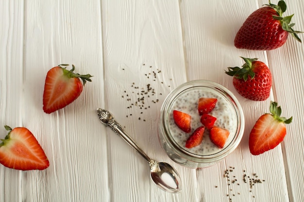 Pudding with chia and strawberry on the white wooden backgroundTop view