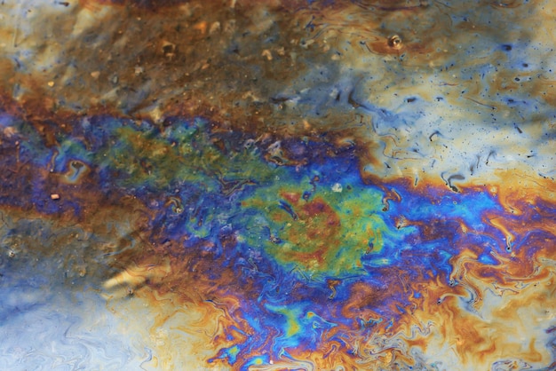 puddle gasoline background, wet oil multicolored rainbow pollution spill