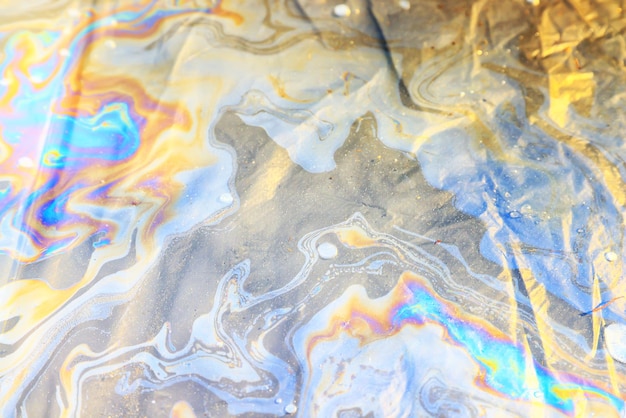 puddle gasoline background, wet oil multicolored rainbow pollution spill