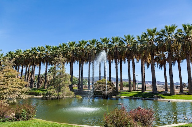 Pueblos de America park in Motril Spain with a fountain in the middle of the lake and palm trees