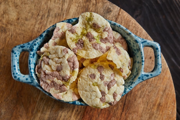 Puff chips with chickpeas peas and beans in bowl on wooden background