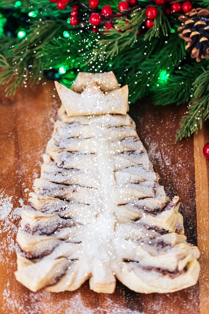 Puff pastry cookies in the shape of a Christmas tree on a wooden cutting Board