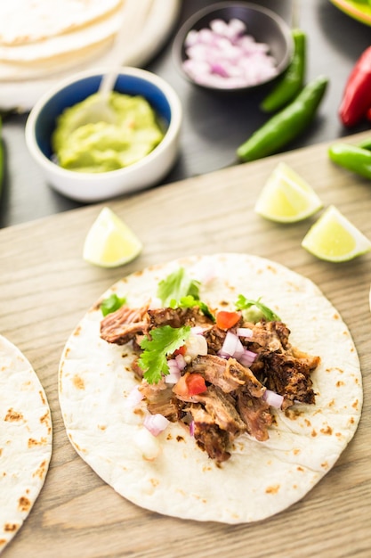 Pulled pork carnitas with pico de gallo on a flour tortilla.