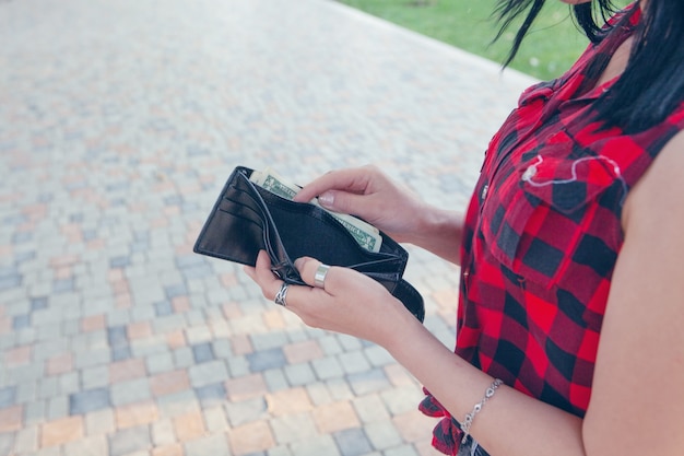 Pulls money out of his wallet on the street