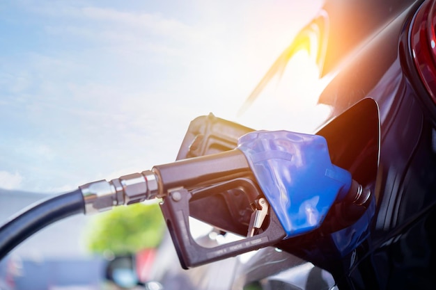 Photo pumping gasoline fuel in black car at gas station