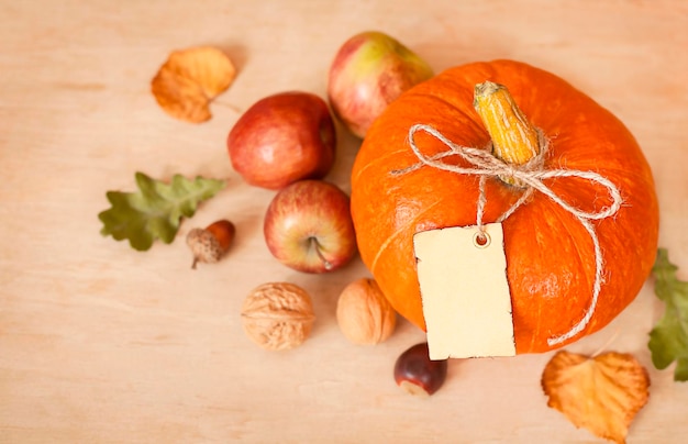 pumpkin, apples and dry leaves on a wooden table. View from above