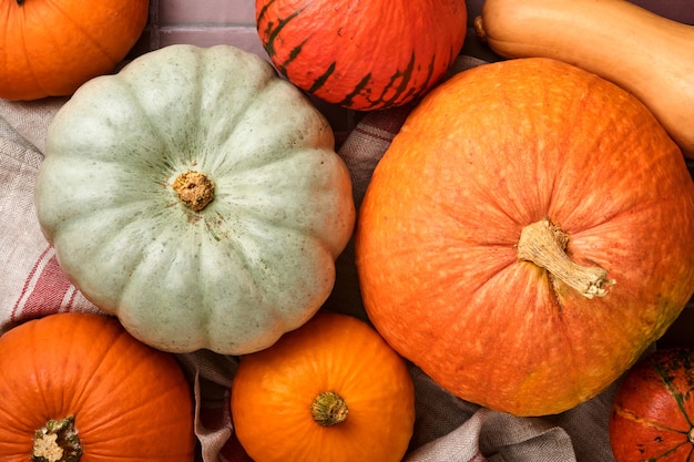 Pumpkin. Autumn food background with cinnamon, nuts and seasonal spices on old ceramic tiles background. Cooking pumpkin or apple pie and cookies for Thanksgiving and autumn holidays. Top view.