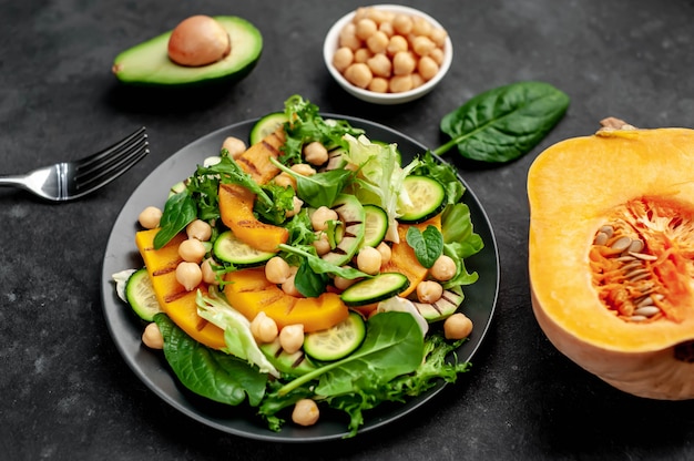 pumpkin, avocado, cucumber, chickpeas, salad on a plate. Tasty healthy salad