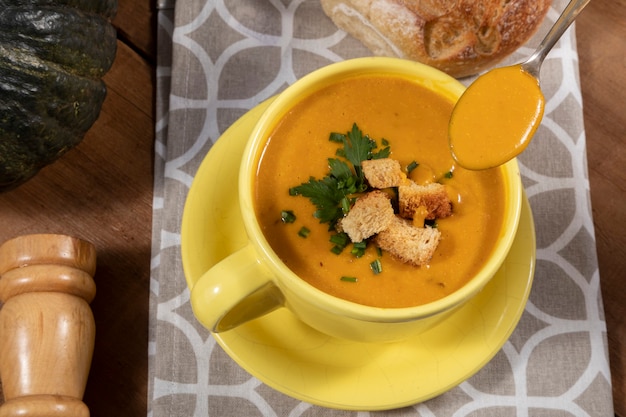 Photo pumpkin broth on wooden background.