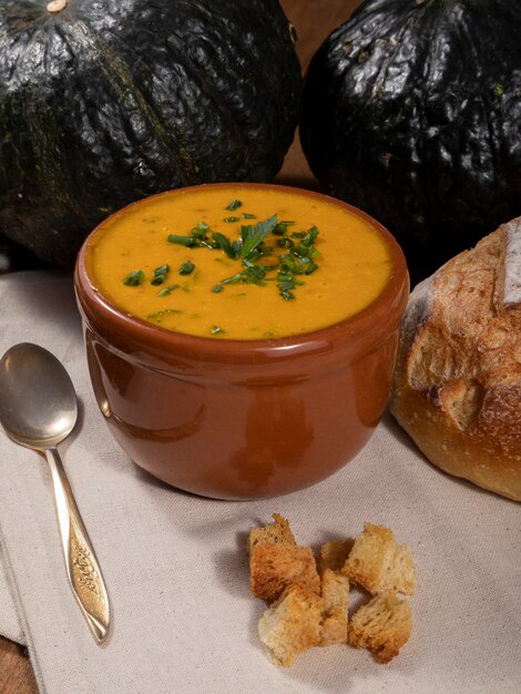 Photo pumpkin broth on wooden background.