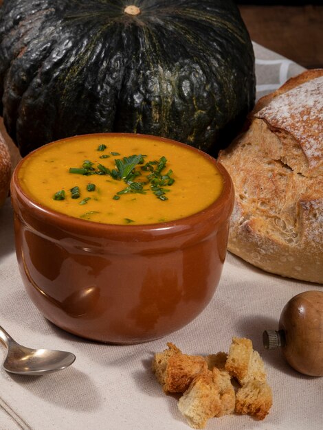 Photo pumpkin broth on wooden background.