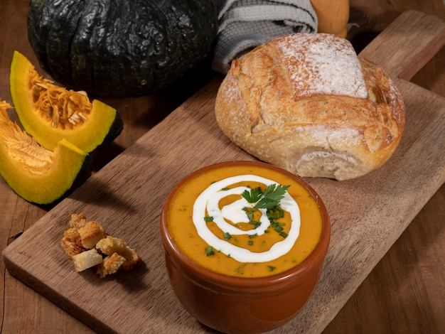 Pumpkin broth on wooden background.