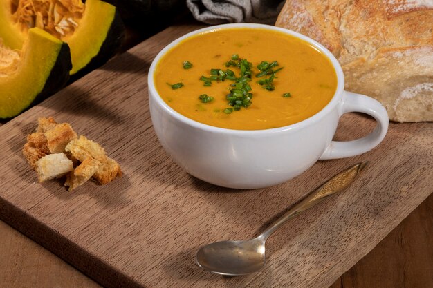 Pumpkin broth on wooden background.