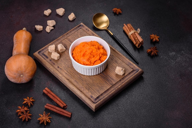 Pumpkin carrot baby puree in bowl on a dark background top view Fresh orange squash vegetable pumpkin carrot puree