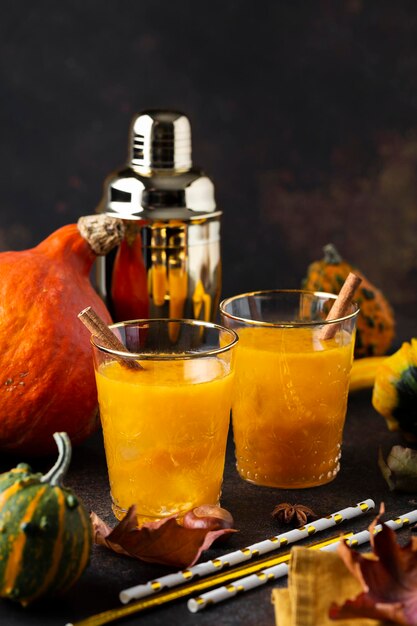 Pumpkin cocktail with autumn decor on wooden table