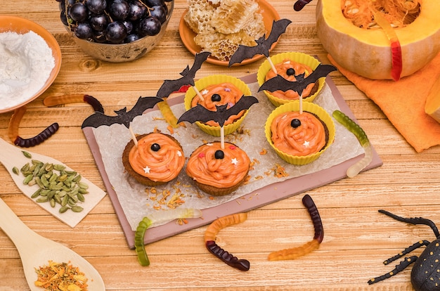 Pumpkin cupcakes with orange cream for Halloween. Ideas for baking, sweets.