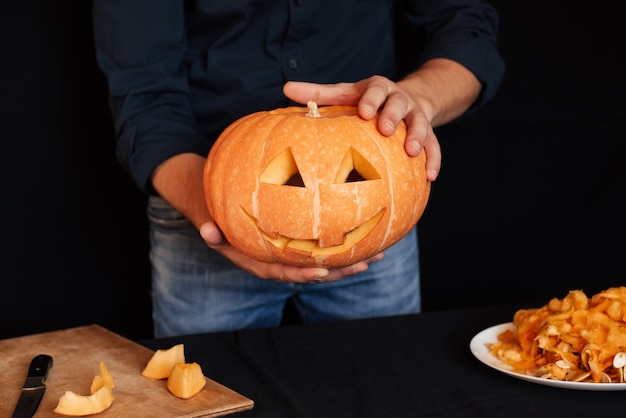 Pumpkin for Halloween in the hands of men