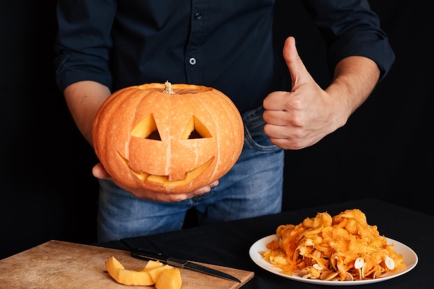 Pumpkin for Halloween in the hands of men