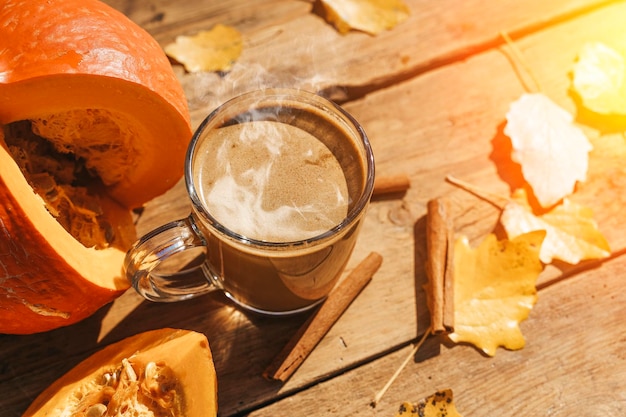 Pumpkin latte coffee with spices and cinnamon Autumn hot drink on a rustic wooden table decorated