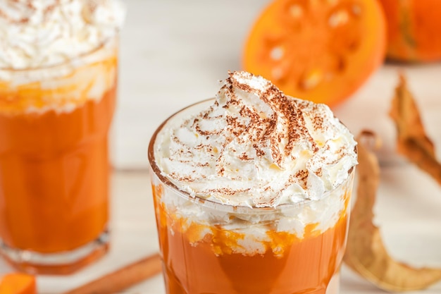 Pumpkin latte with whipped cream on light wooden background Hot spicy smoothie Vegetable vegan drink