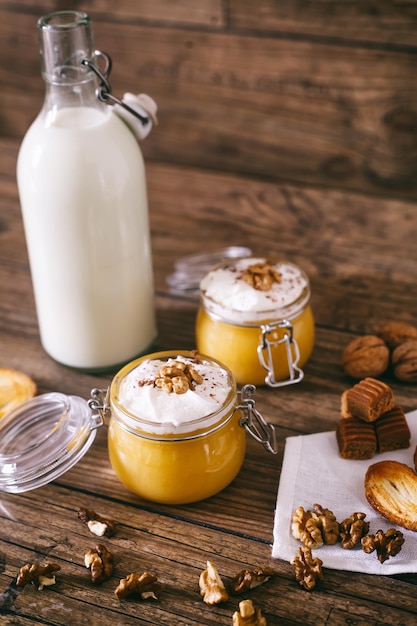 Pumpkin milkshake in glass jar with whipped cream toffee walnut and honey cookies bottle of milk dar