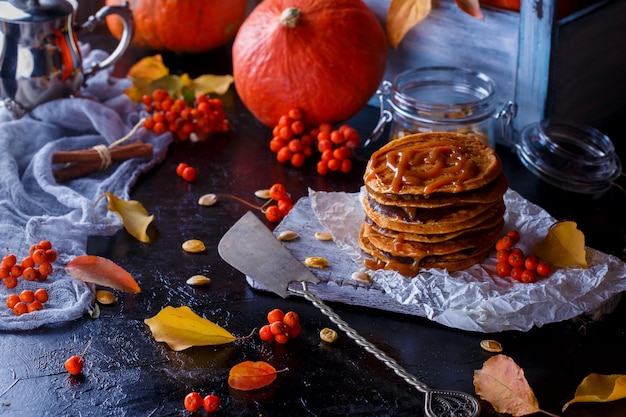 Pumpkin pancakes with caramel topping, with pumpkins, leaves  .