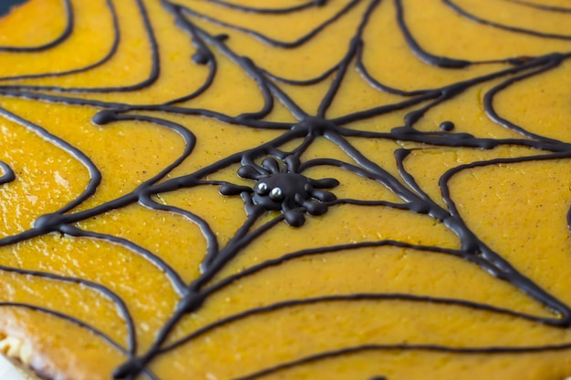 Pumpkin pie A cake decorated on Halloween with a black cobweb of chocolate Chocolate spider in the web