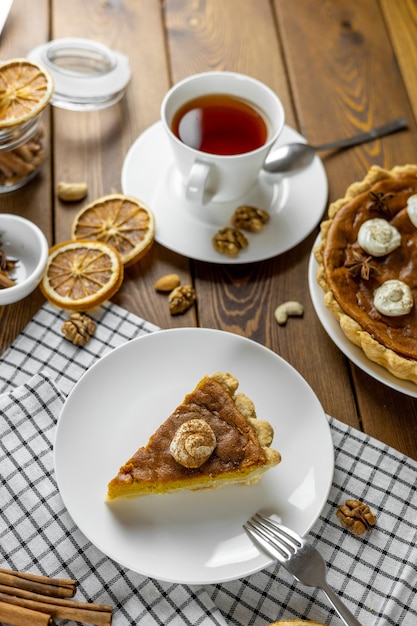 Pumpkin pie thanksgiving pie with whipped cream on a white plate View from above