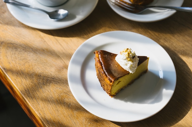 Pumpkin pie on the wooden table with afternoon light.