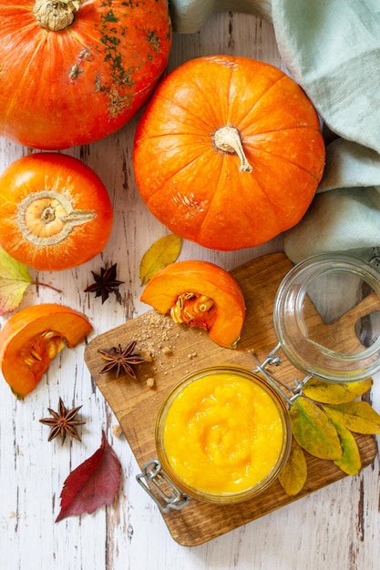 Pumpkin Puree with spices and Pumpkin on a wooden table Top view flat lay background