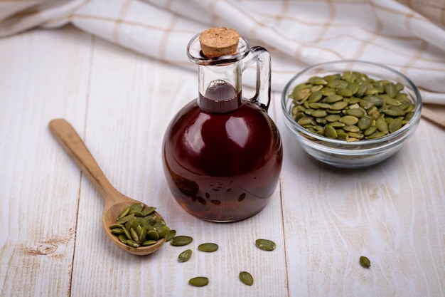 Pumpkin seed oil in a glass vessel and pumpkin seeds closeup space for copying and selective focus