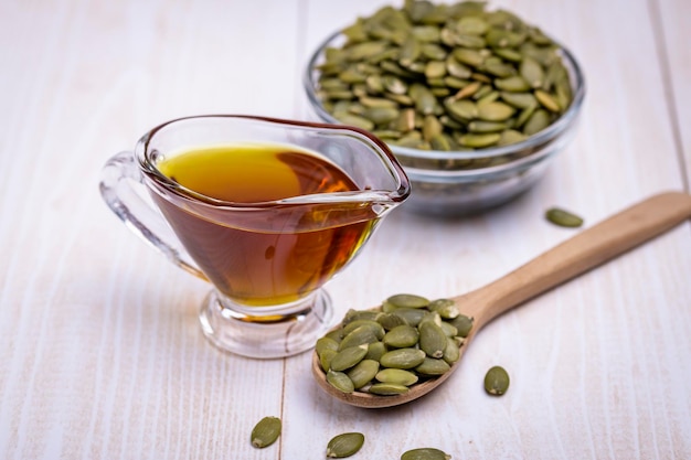 Pumpkin seed oil in a glass vessel and pumpkin seeds closeup space for copying and selective focus