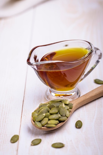 Pumpkin seed oil in a glass vessel and pumpkin seeds closeup space for copying and selective focus