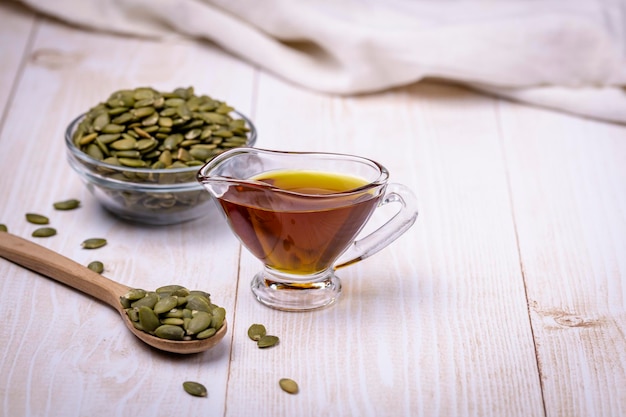 Pumpkin seed oil in a glass vessel and pumpkin seeds closeup space for copying