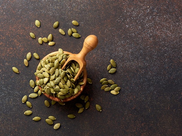 Pumpkin seeds on brown background. Top view.