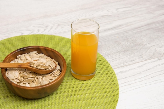 Pumpkin seeds in a cup with a glass of pumpkin juice slimming and detox