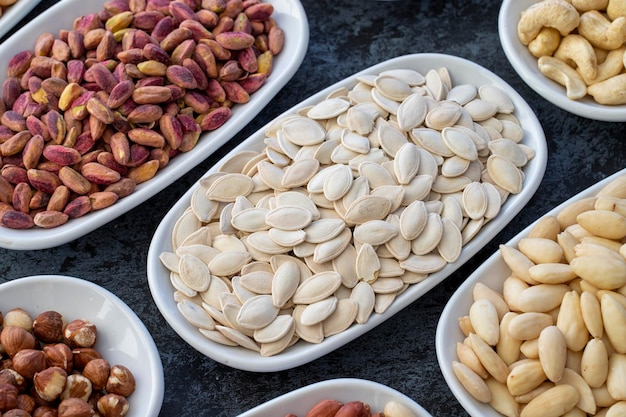 Pumpkin Seeds in selective focus Types of nuts found in bulk on a dark background Top view nuts