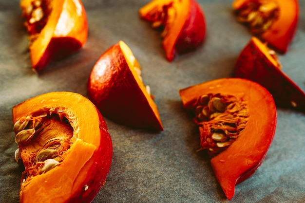 Pumpkin slices with bones on baking parchment. Raw cored pumpkin on baking sheet, soft focus