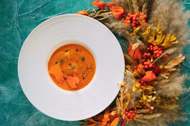 Pumpkin soup on a green background. the view from the top.